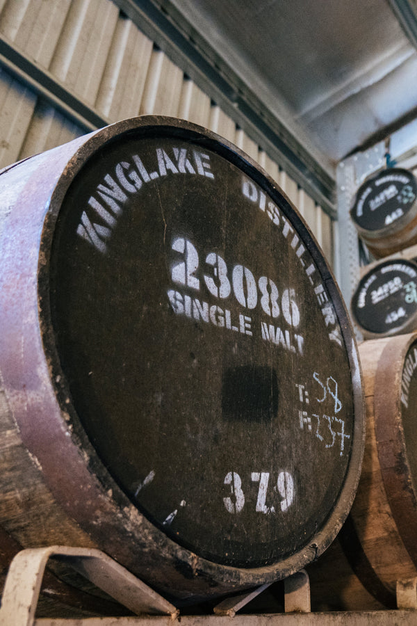 Whiskey barrels with labels in a storage room