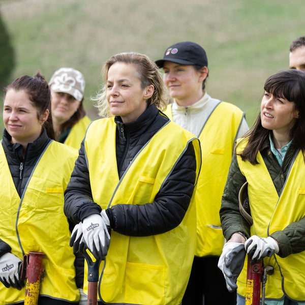 Group of people wearing yellow vests on a golf course